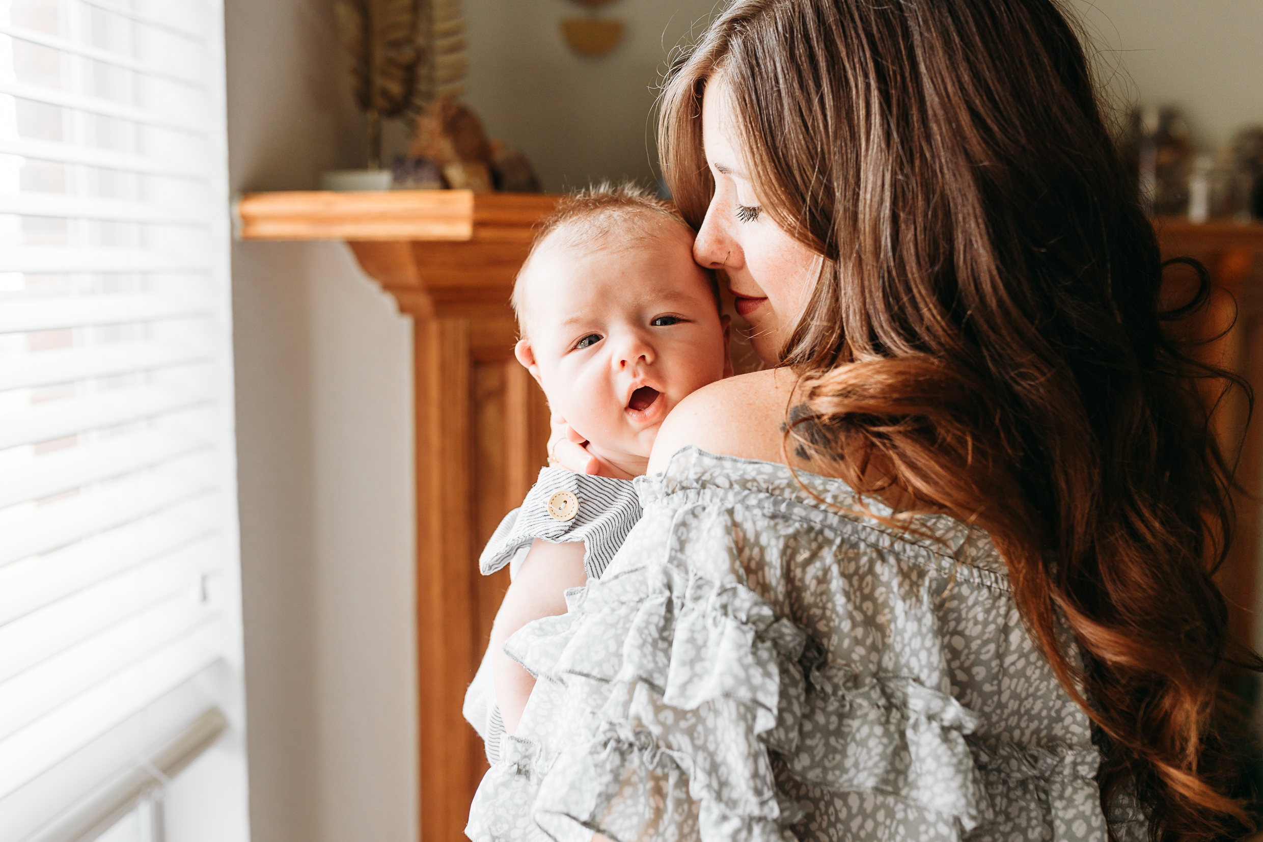 A mother snuggles newborn during photo session.
