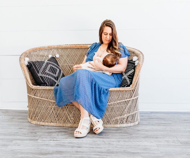 A mother sits to nurse her baby during her OKC mini breastfeeding session.