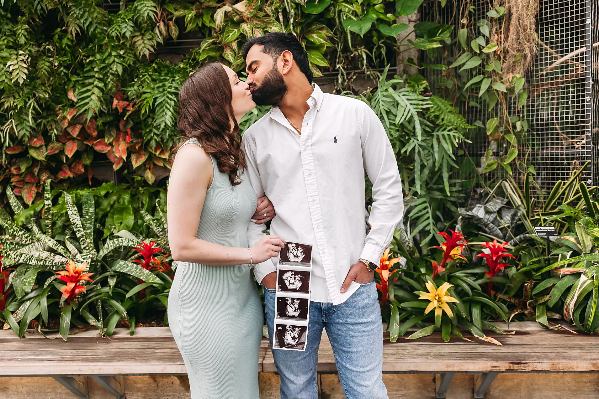 Couple kisses during pregnancy announcement photos at myriad gardens in OKC.