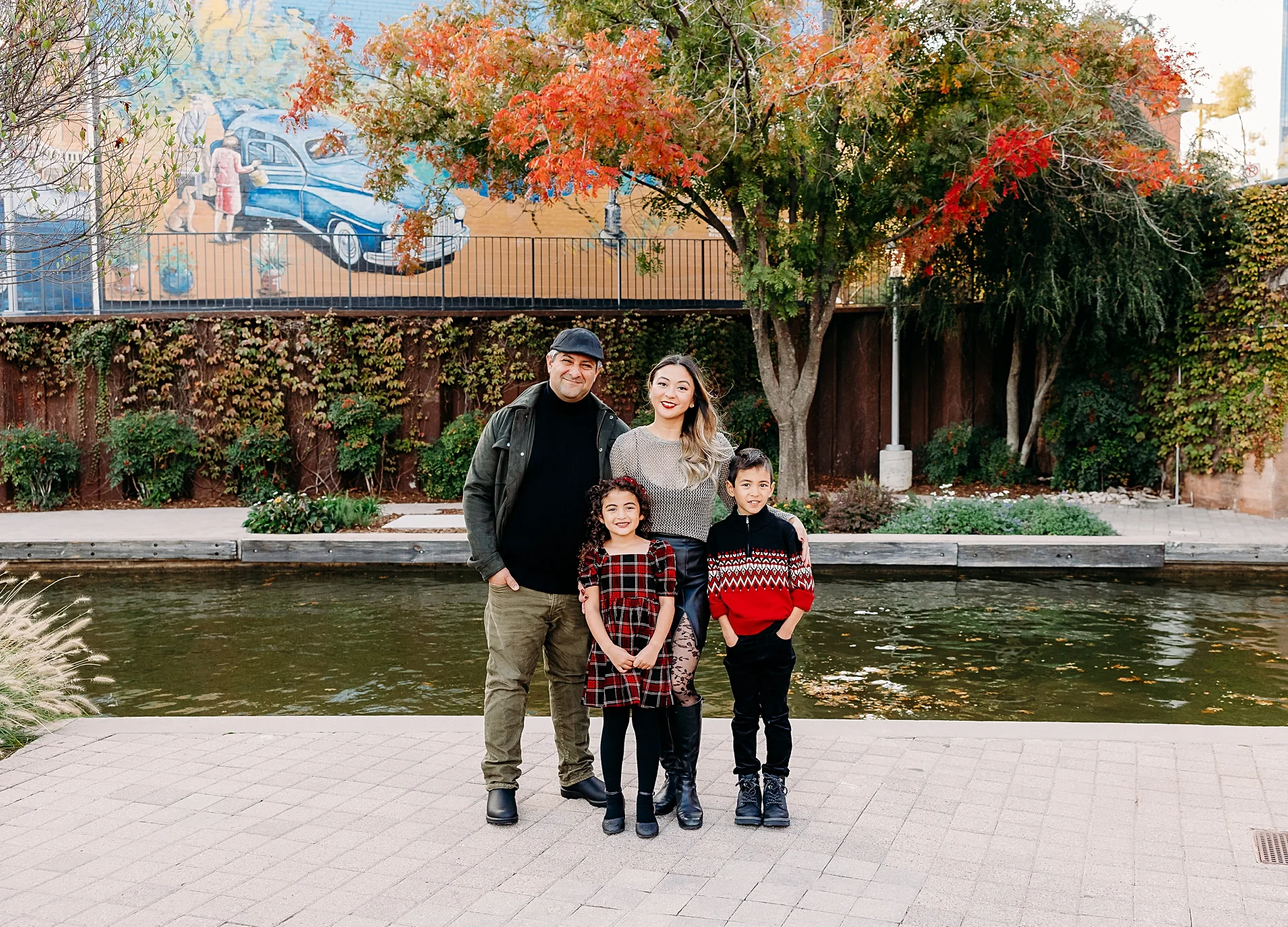 Family of 4 take family photos alongside the Bricktown canal as one of the best places to take family photos in OKC.