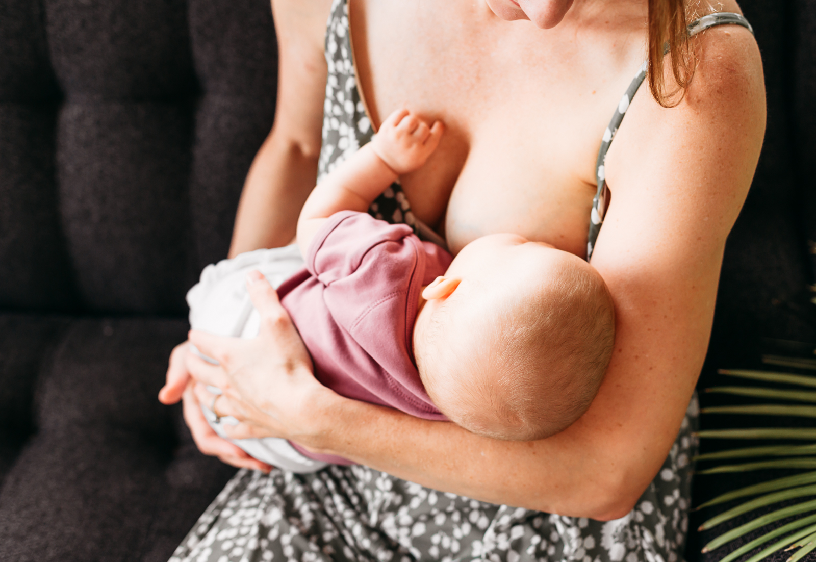 Baby nurses in mother's arms.