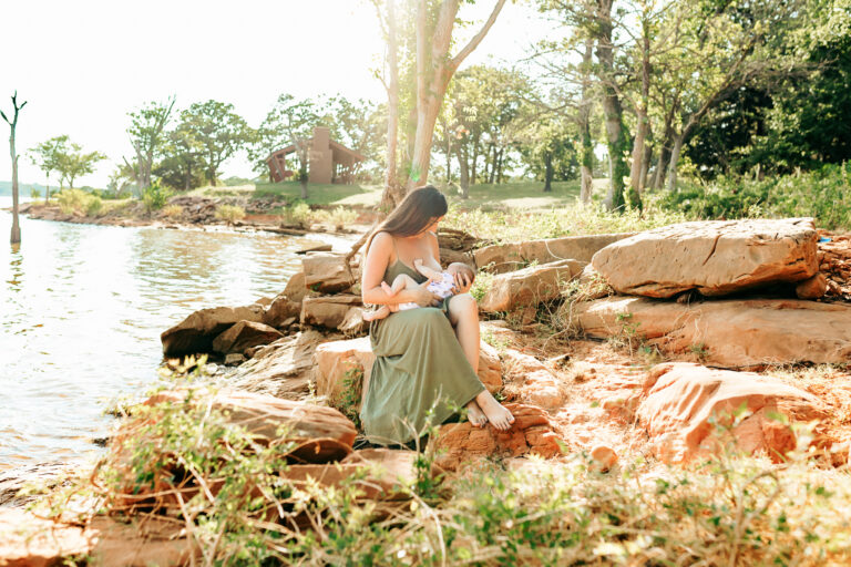 mama nurses her baby at the lake during photo session.