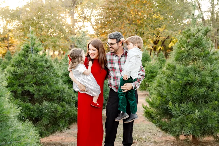 Family of 4 in holiday clothes at Wells Christmas Tree Farm for Christmas Photos.