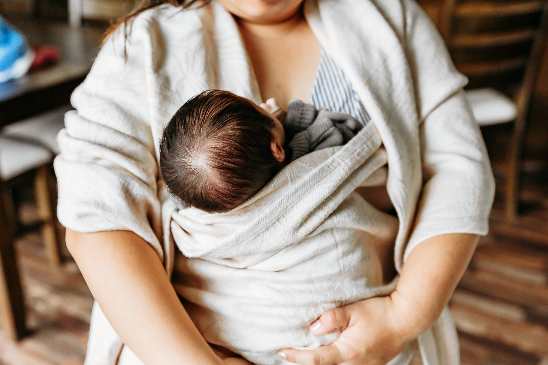 Mom holds baby in a wrap during Edmond newborn photo session.