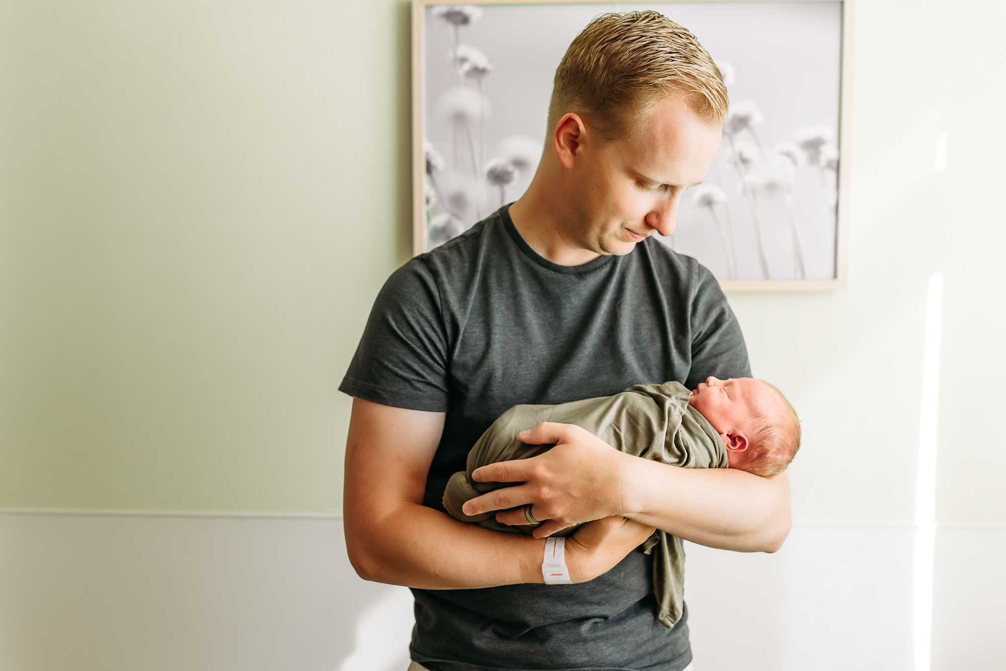 Dad holds son during hospital baby photos with OKC fresh 48 photographer.