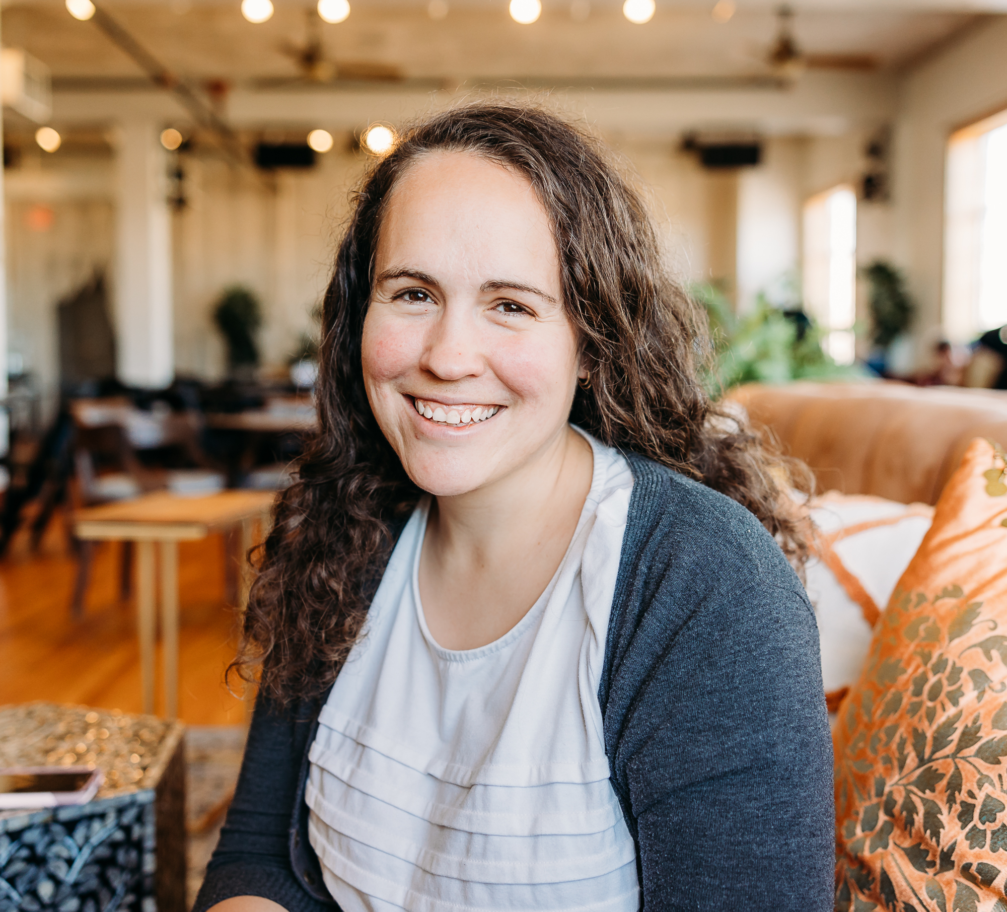 Charis, an OKC photographer in a white shirt and blue sweater 