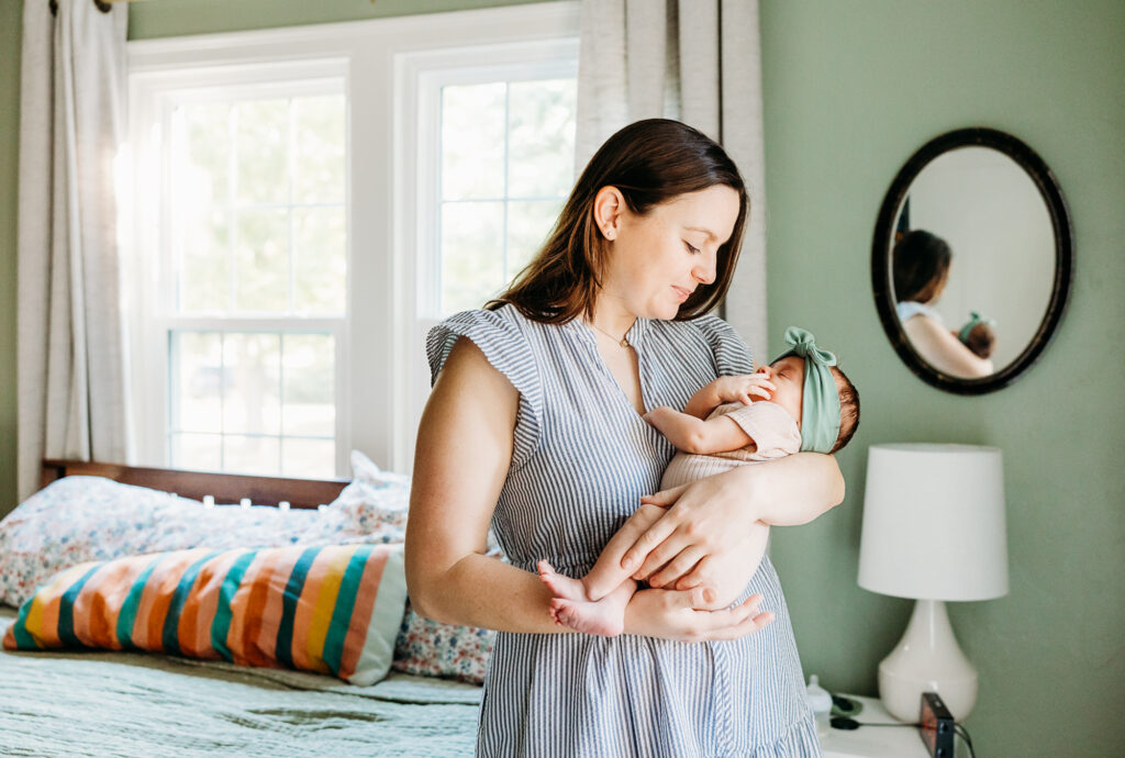Mom holds newborn baby in arms.