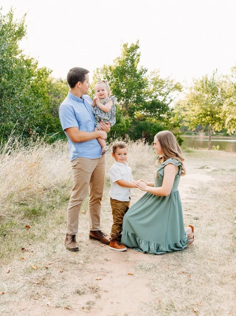 Dad plays with daughter and mom plays with son during family photos at Whispering Heights Park.