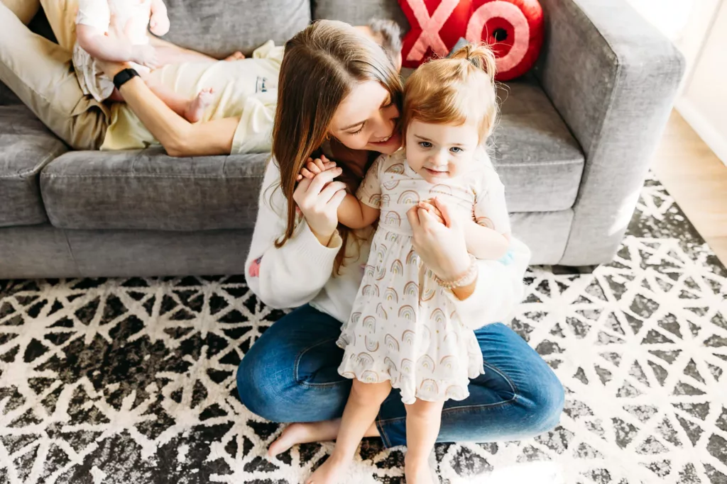 Mom snuggles baby during family photos.