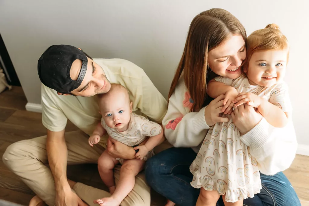 Family sits on floor during family photos.