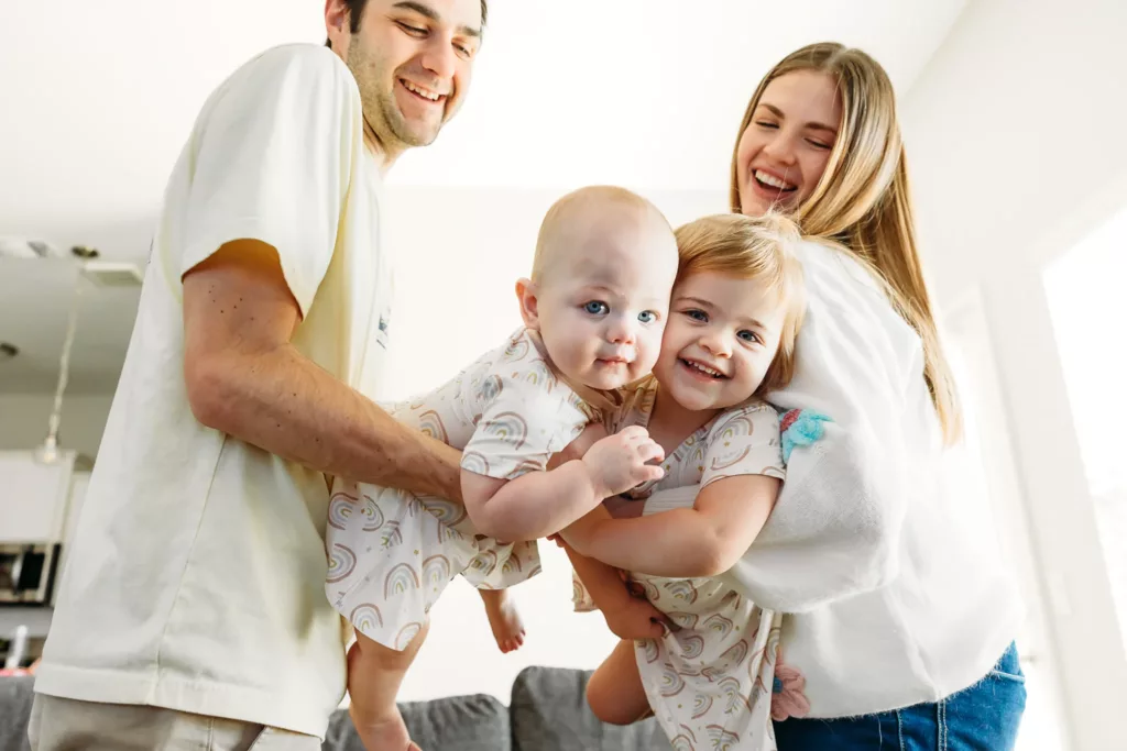 Sisters hug each other during play time during family photos.