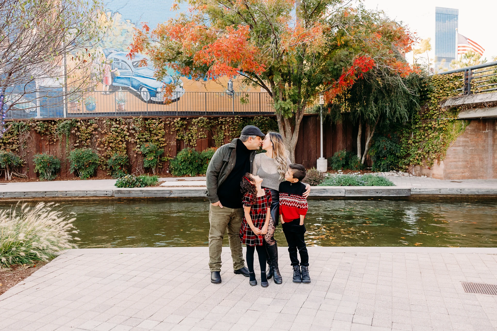 Mom, dad and two elementary age kids stand by the river canal in OKC.
