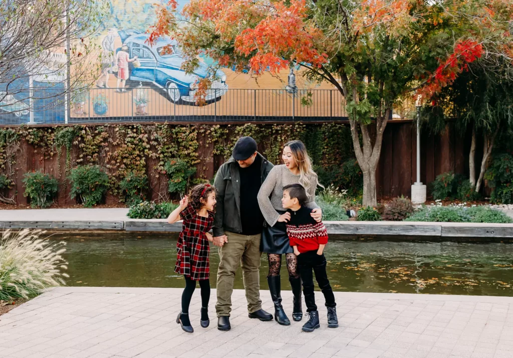 Family of four laughs together during family photos in Bricktown, OKC.