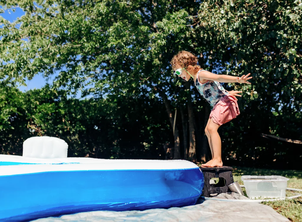 girl jumping into pool in summer