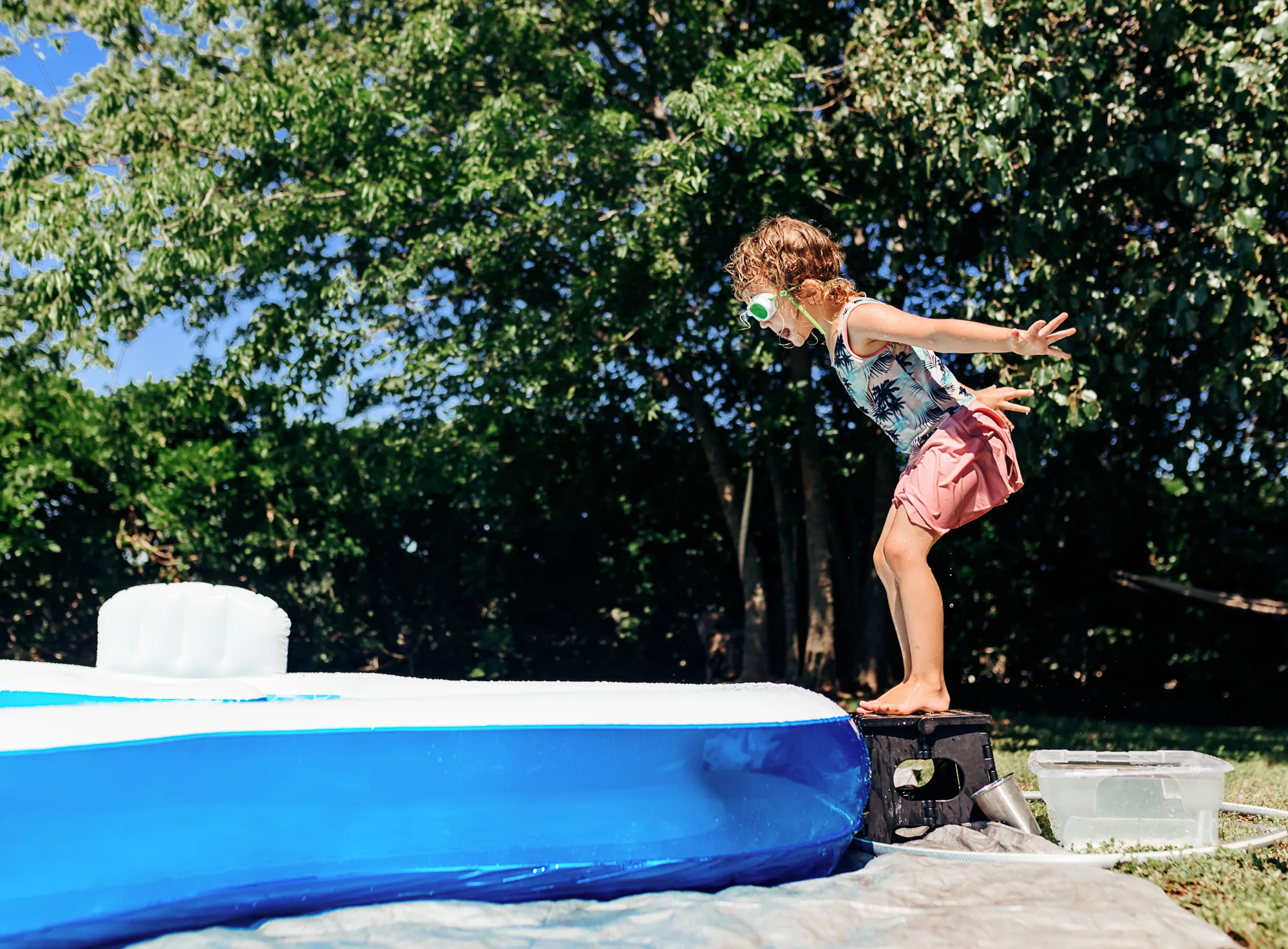 girl jumping into pool in summer