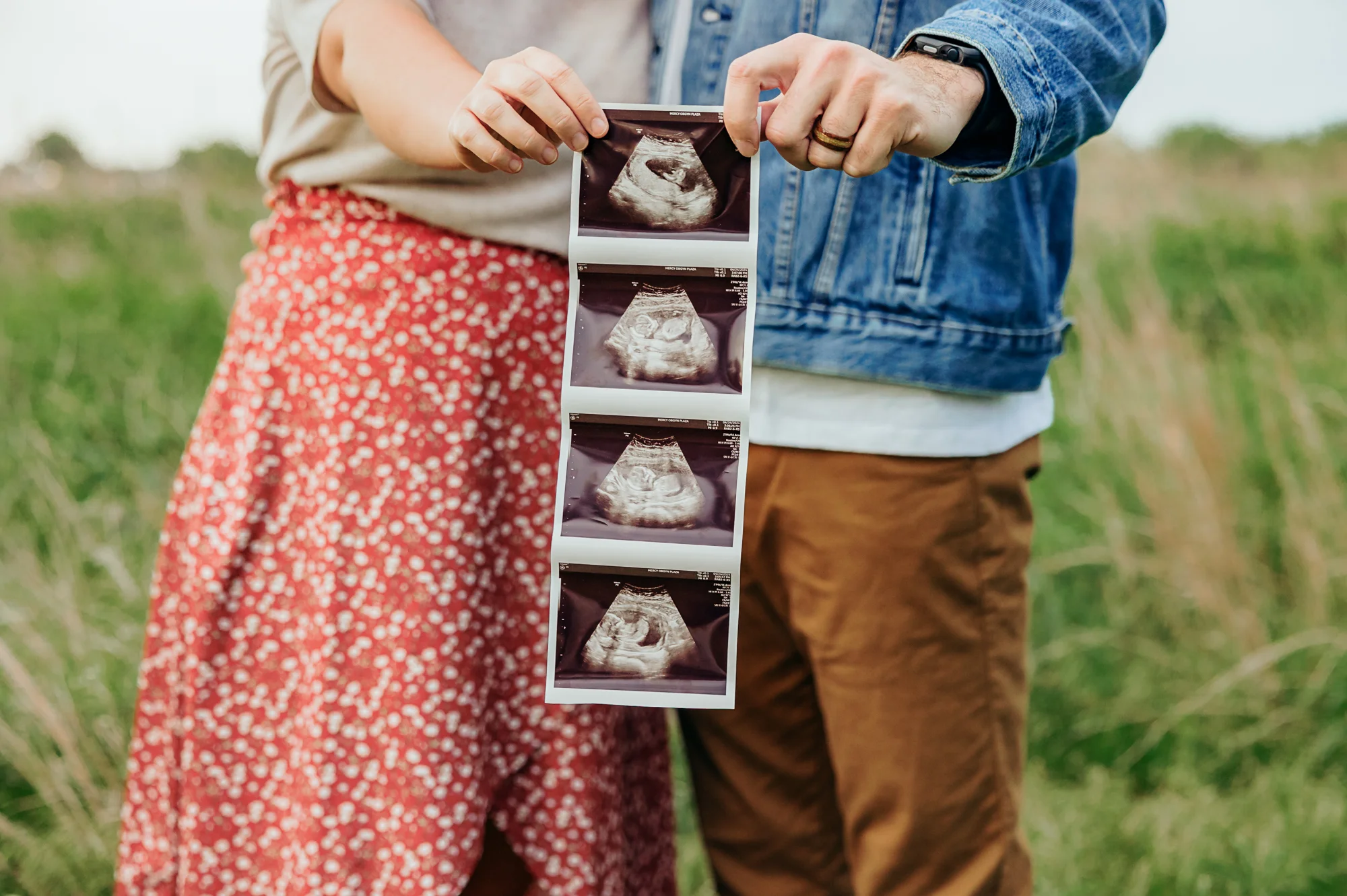 Couple with sonogram pictures for baby announcement photo.