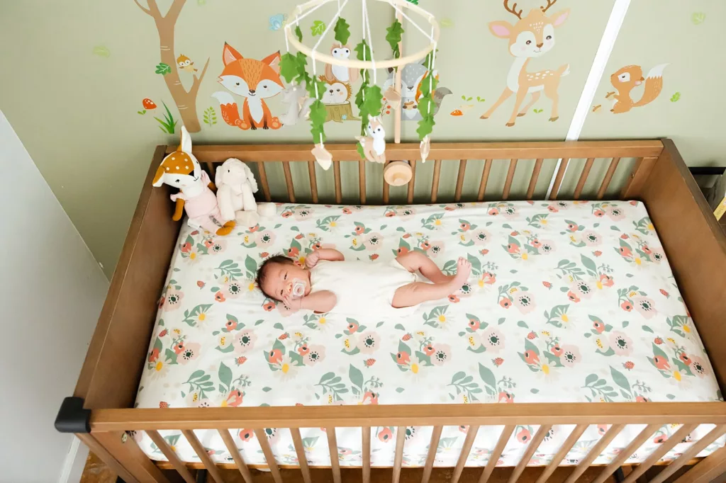 Baby girl lies in crib in nursery during newborn photos.