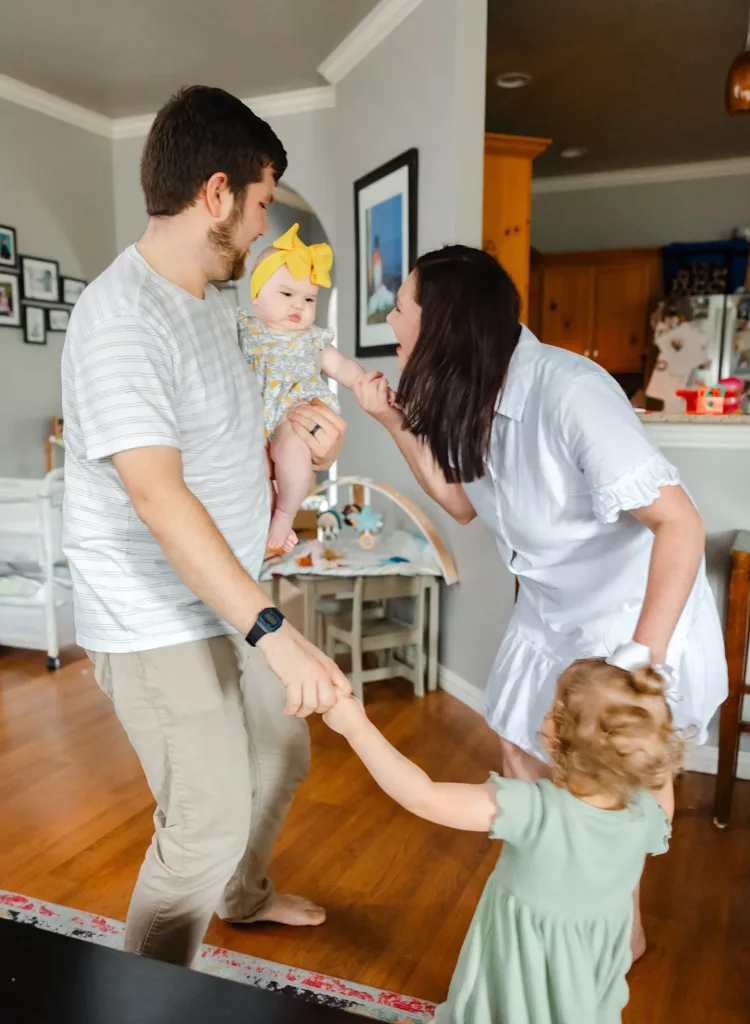 Family has dance party during family photos at home.