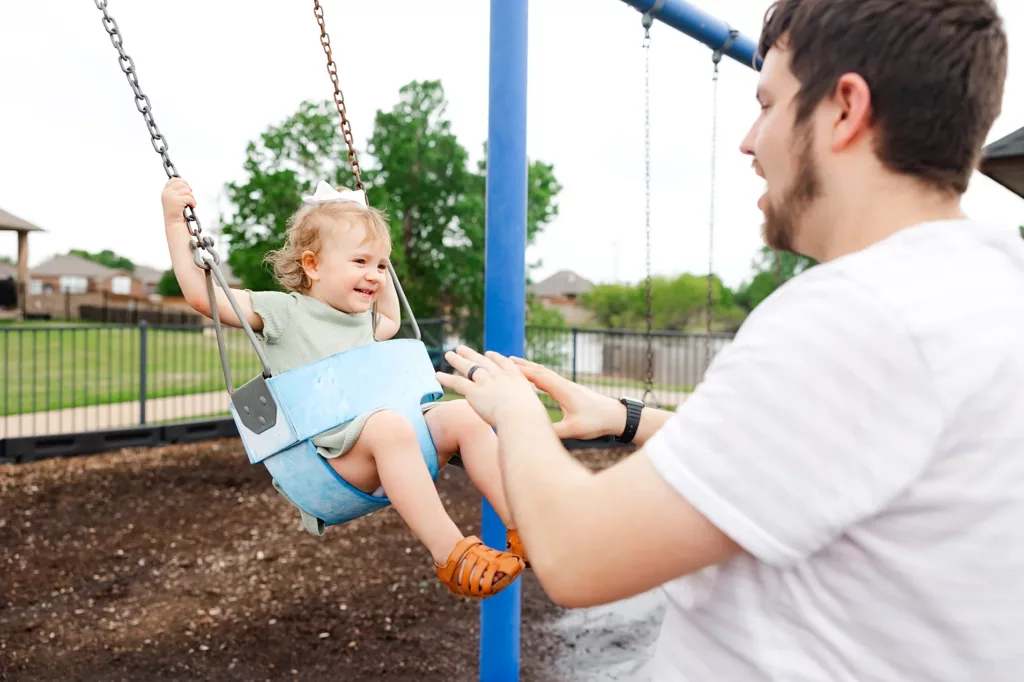 family plays on swings during a lifestyle family photo session.