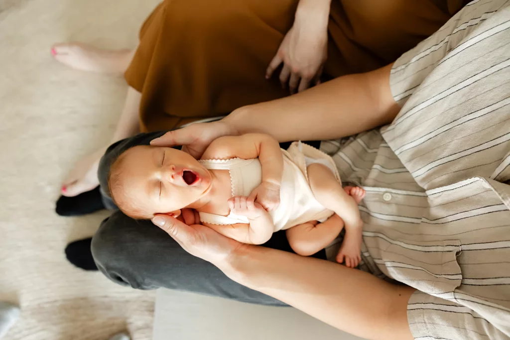 little baby yawns during at home newborn photo session.