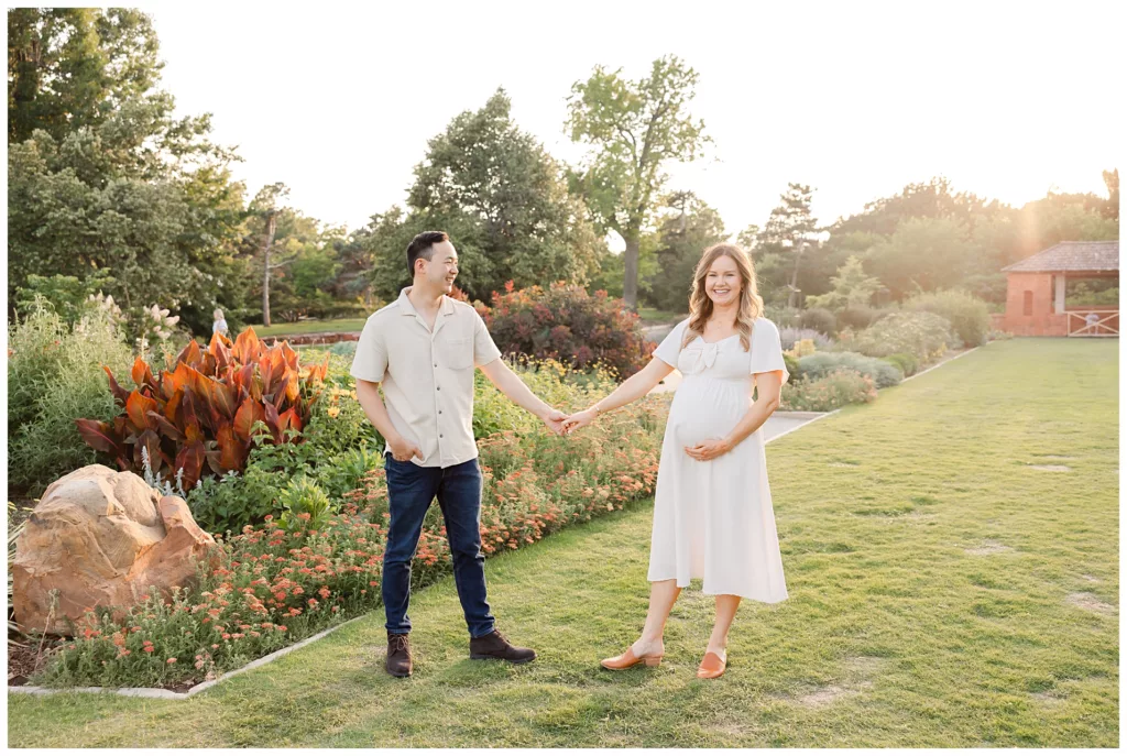 Couple walks in the sunlight during portraits at Will Rogers Gardens.