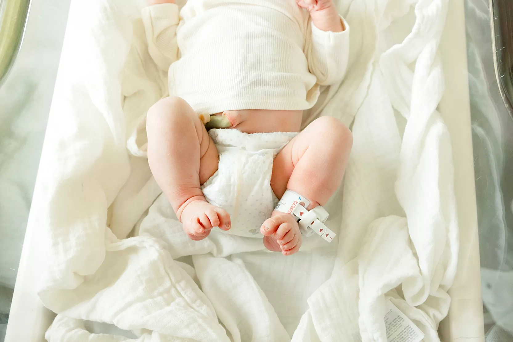 family of 3 plays on bed during in home family photo session