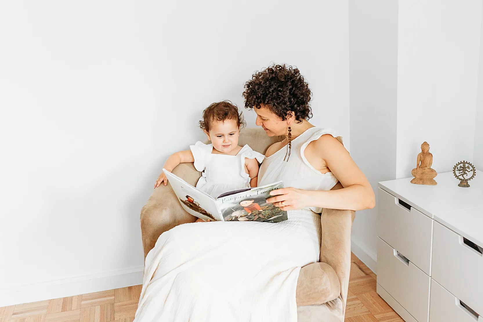 Mom and toddler read a book together during an at home family photo session in Oklahoma City.