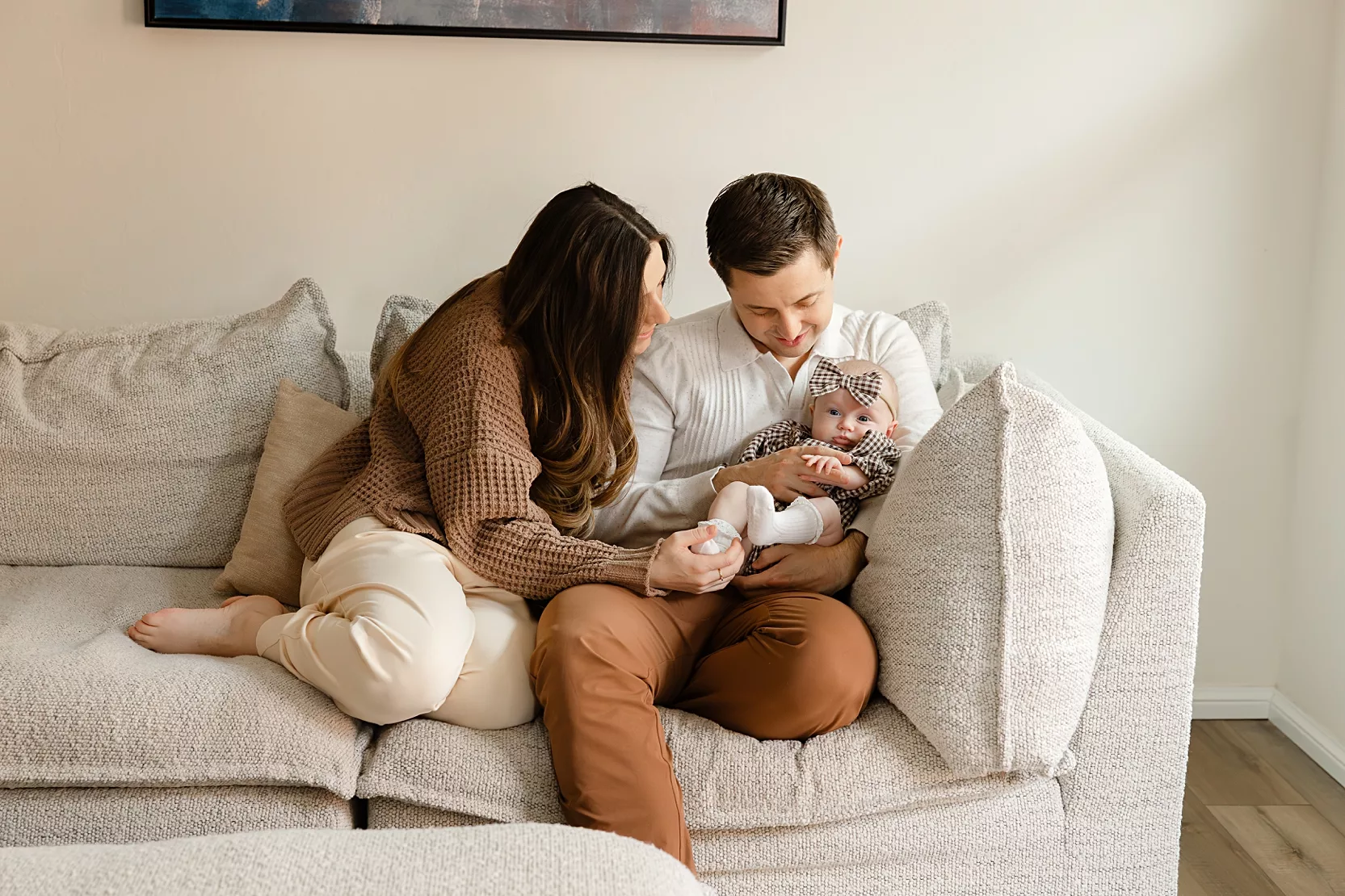 family of 3 plays on bed during in home family photo session