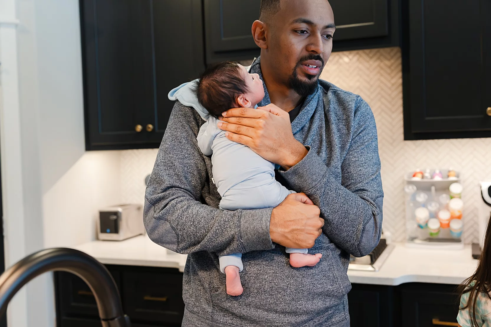 Big brother looks at baby during hospital newborn photos in Oklahoma City.