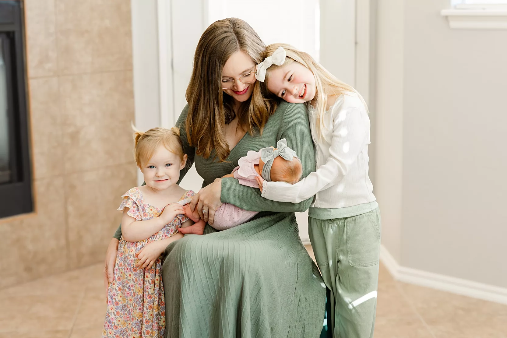 family of 3 plays on bed during in home family photo session