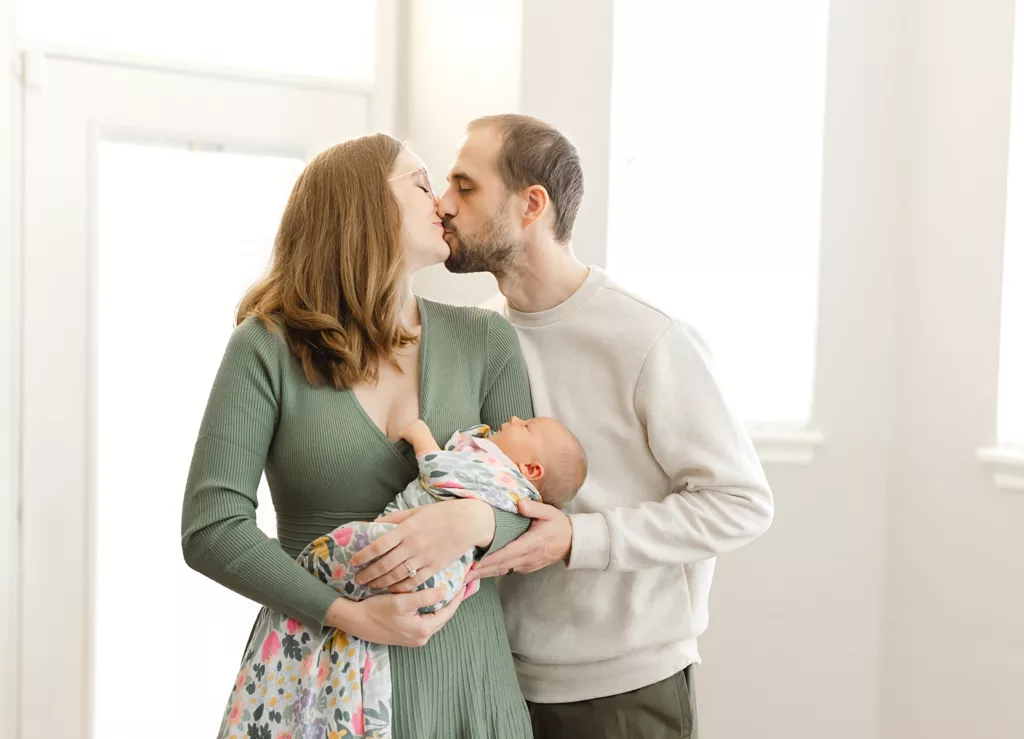 in tips to survive the newborn stage, Oklahoma City Newborn Photographer shares an images of mom and dad with newborn.