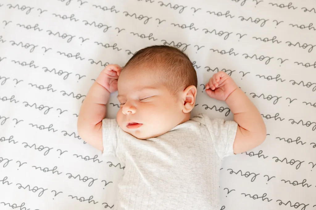 Newborn lies in crib during an at home baby photo session in Oklahoma City.