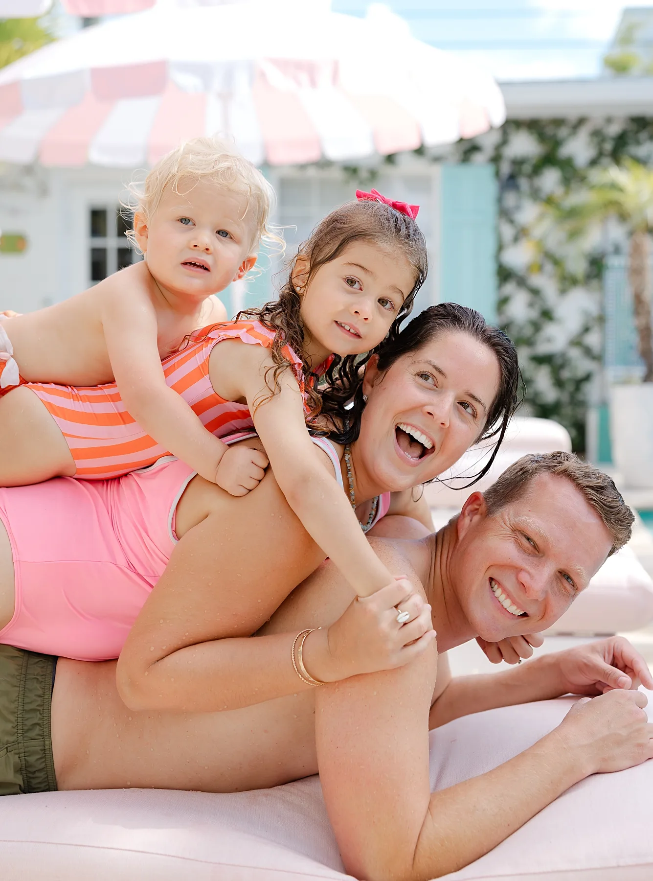 family of 4 with smiles during family photos by the pool by OKC family photographer.