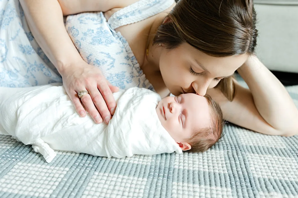 mama kisses her son during her at home newborn photo session.