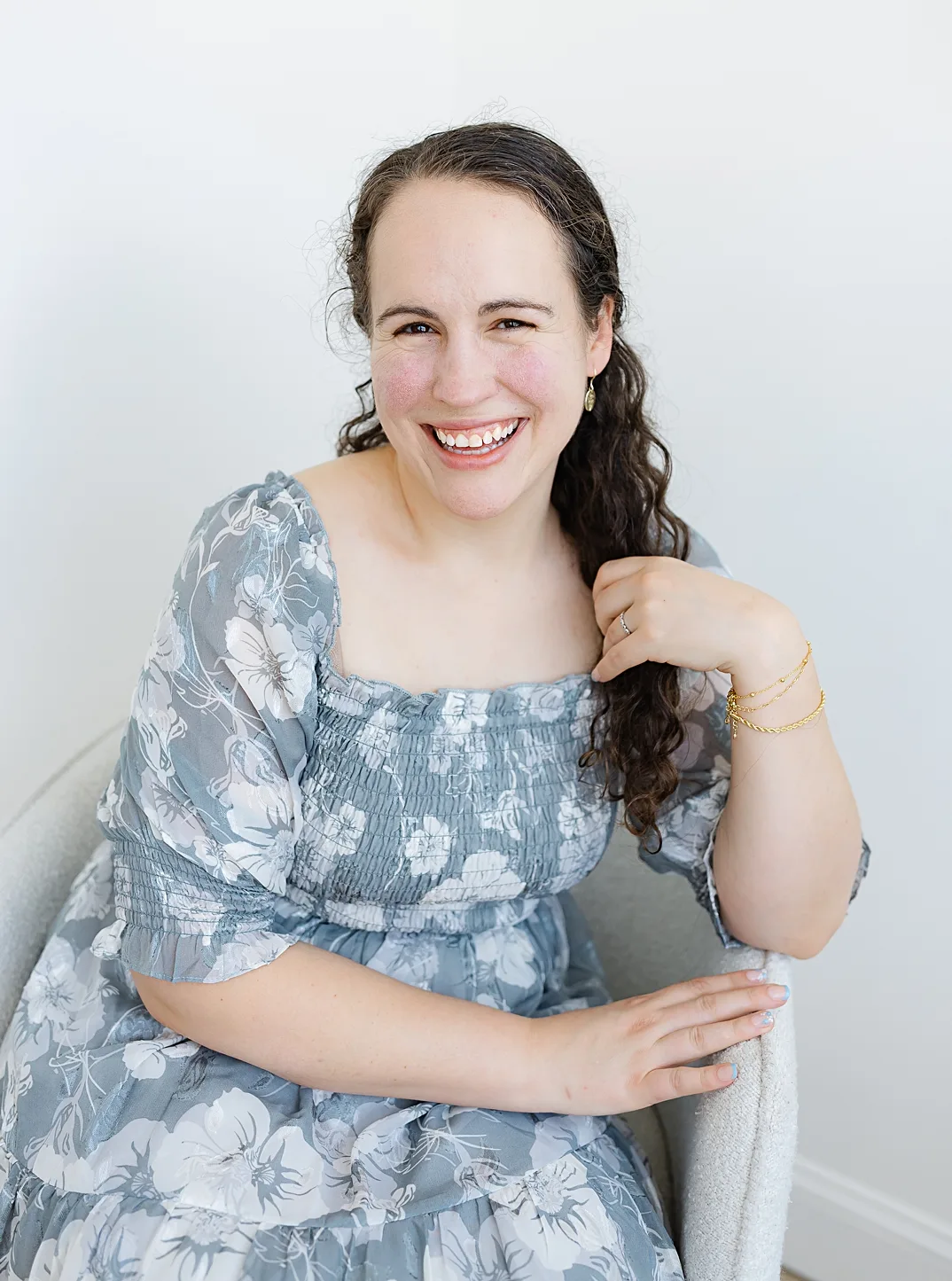 Charis sits on a chair as the owner and head oklahoma city photographer for Charis Elisabeth Photography.