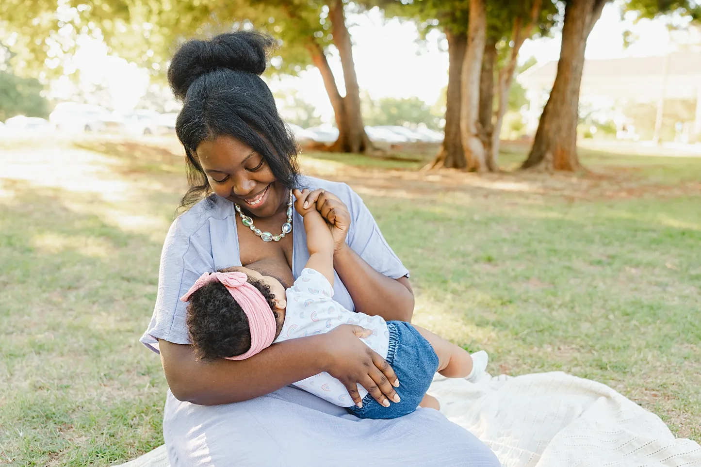A black mama in purple nurses her child during a celebration of breastfeeding in Edmond, OK.