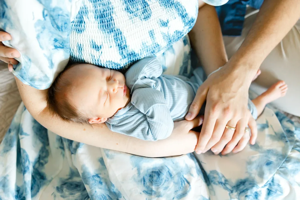 new baby boy in his parents arms during a newborn photo session at home in Oklahoma City.