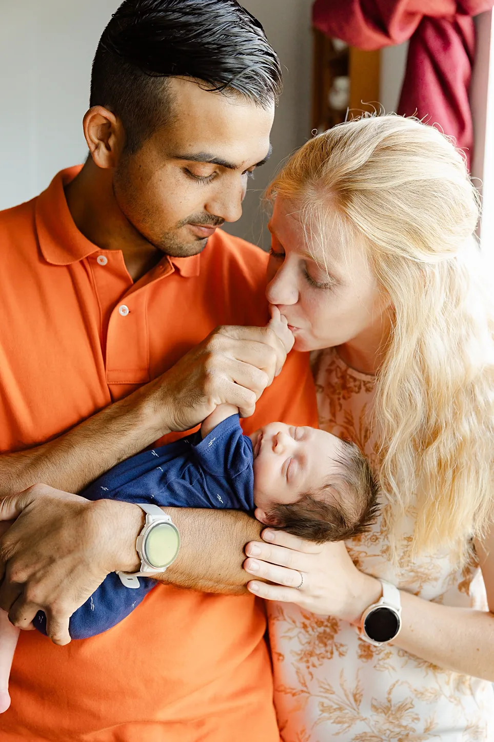 Dad kisses his son during a newborn photo session.