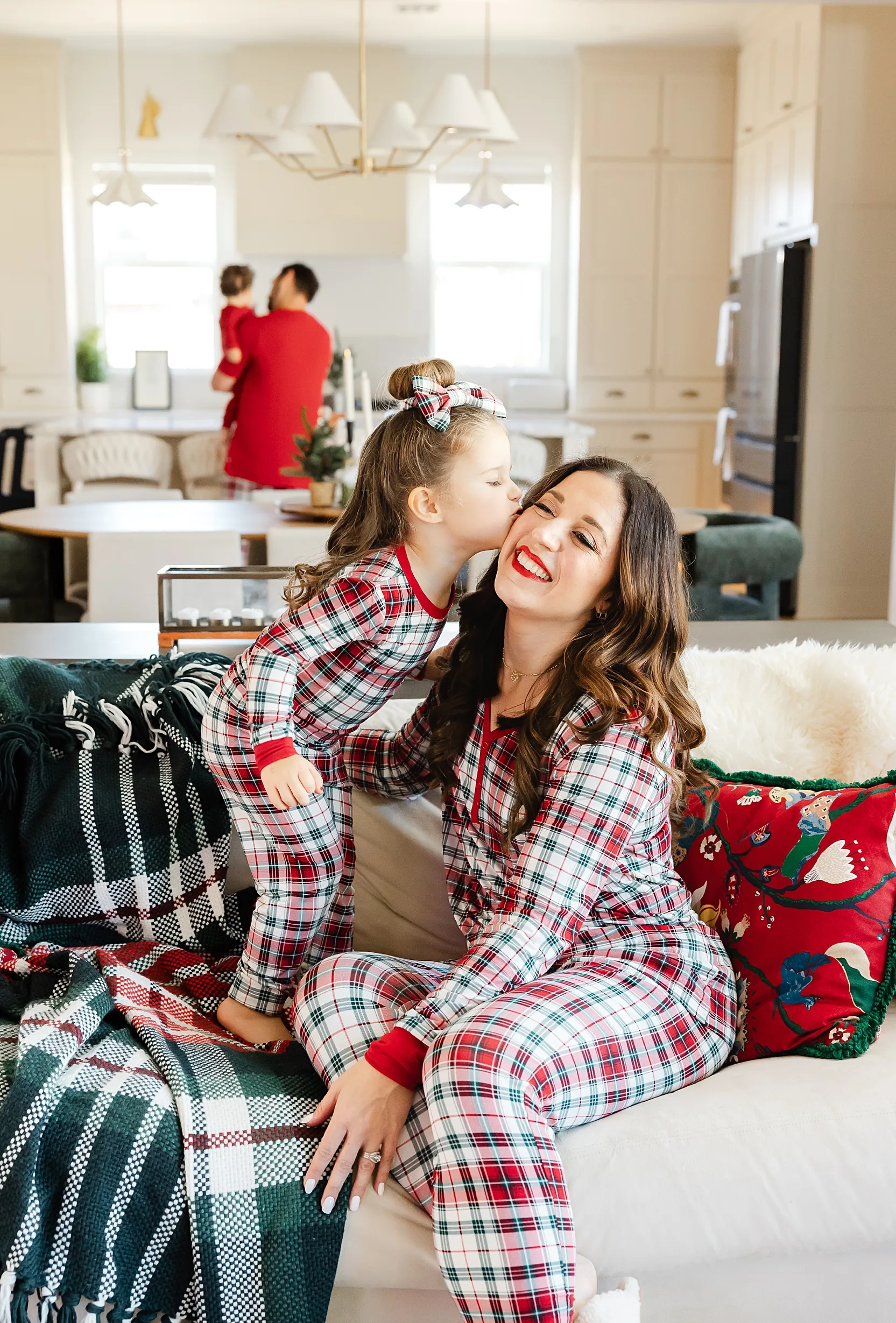 Mom and dad snuggle their baby girl in at home newborn photos. 
